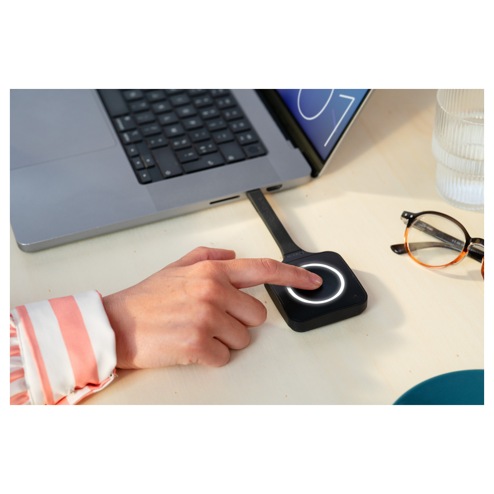 Gebruiker drukt op ClickShare Button bij een laptop